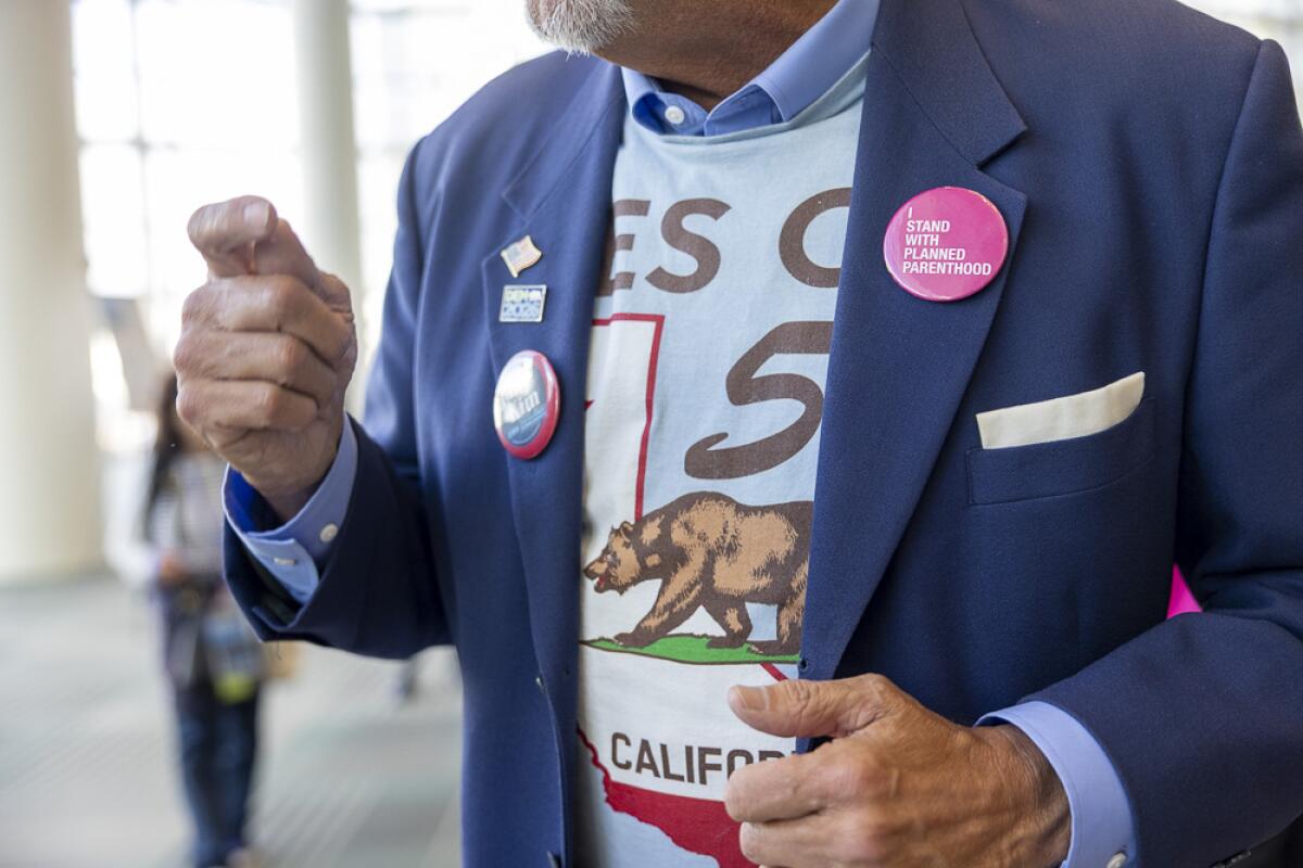 Technology businessman Dennis Bress, from Newport Beach, wears a pin supporting Planned Parenthood