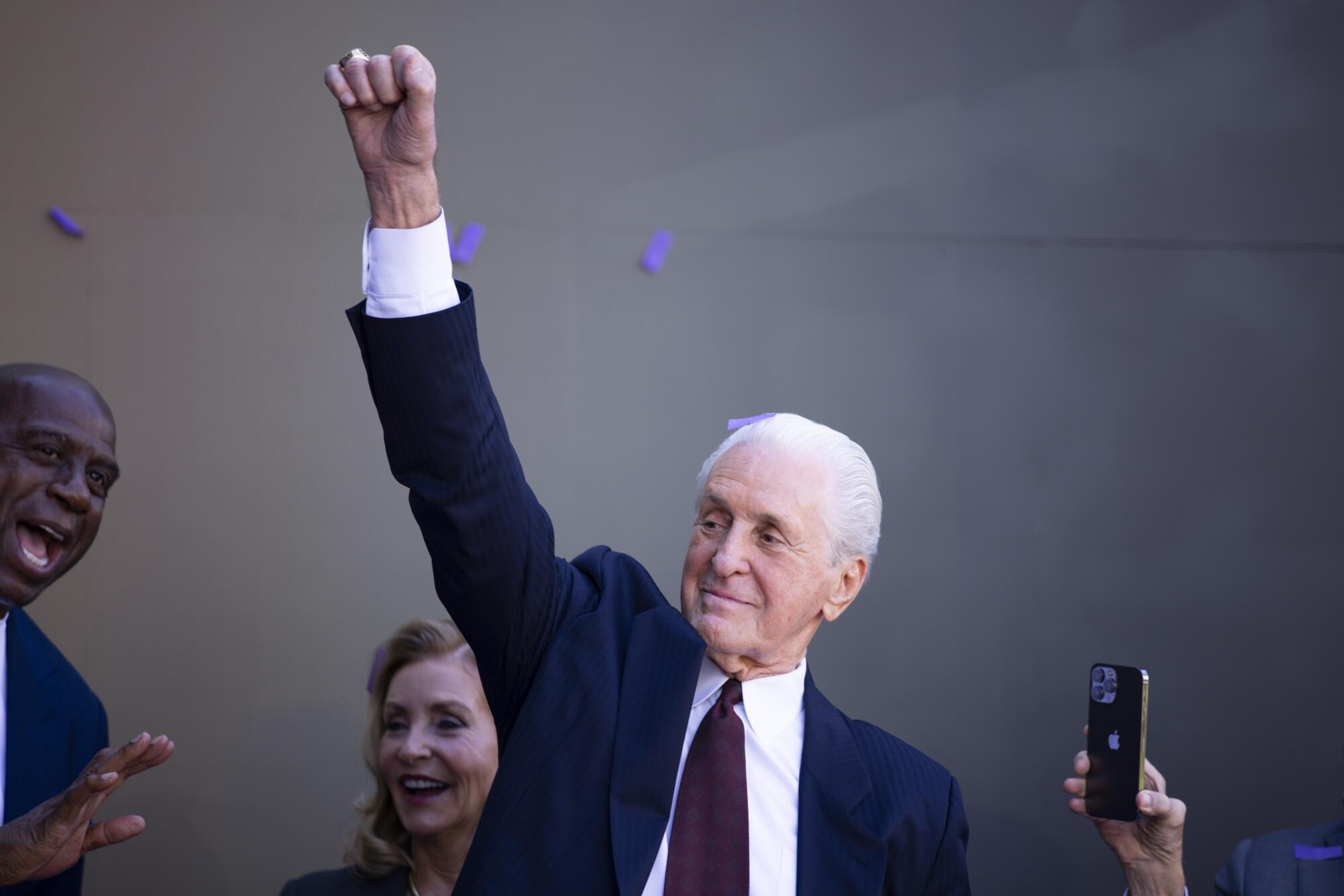 Pat Riley lifts his fist to imitate his statue after it was revealed at Crypto.com Arena on Sunday.
