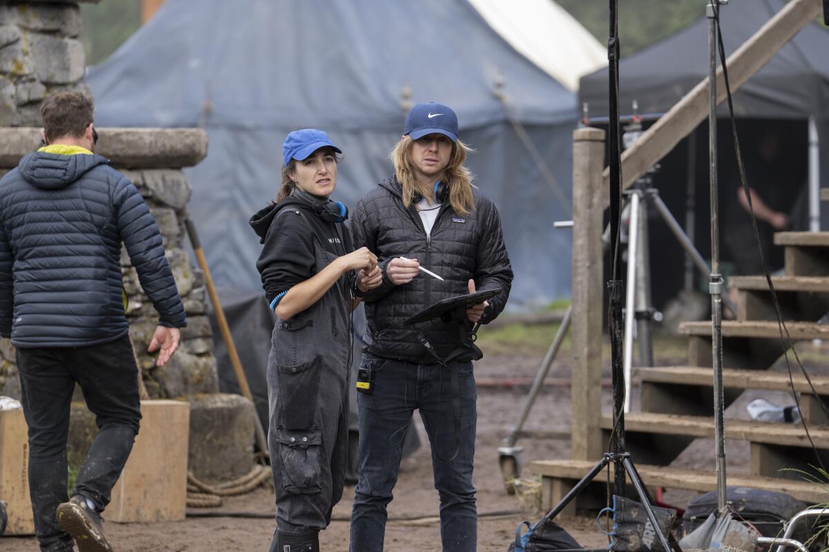 a woman and man wearing hats on a film set