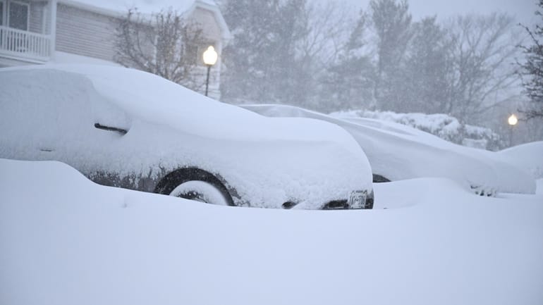 A snowed-in car sits on South Oyster Bay Road in Bethpage on Monday.