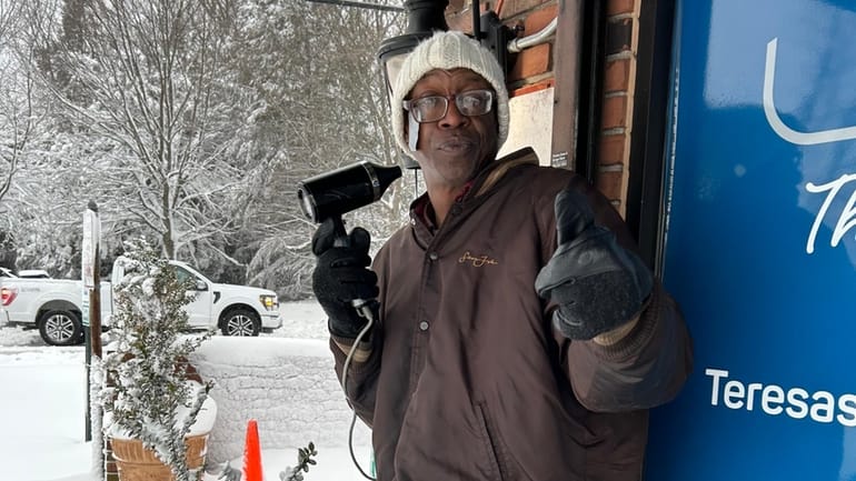 Michael Clemons, 57, uses a portable hair dryer to keep...