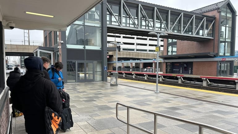 Riders wait for the train at the Mineola LIRR station...