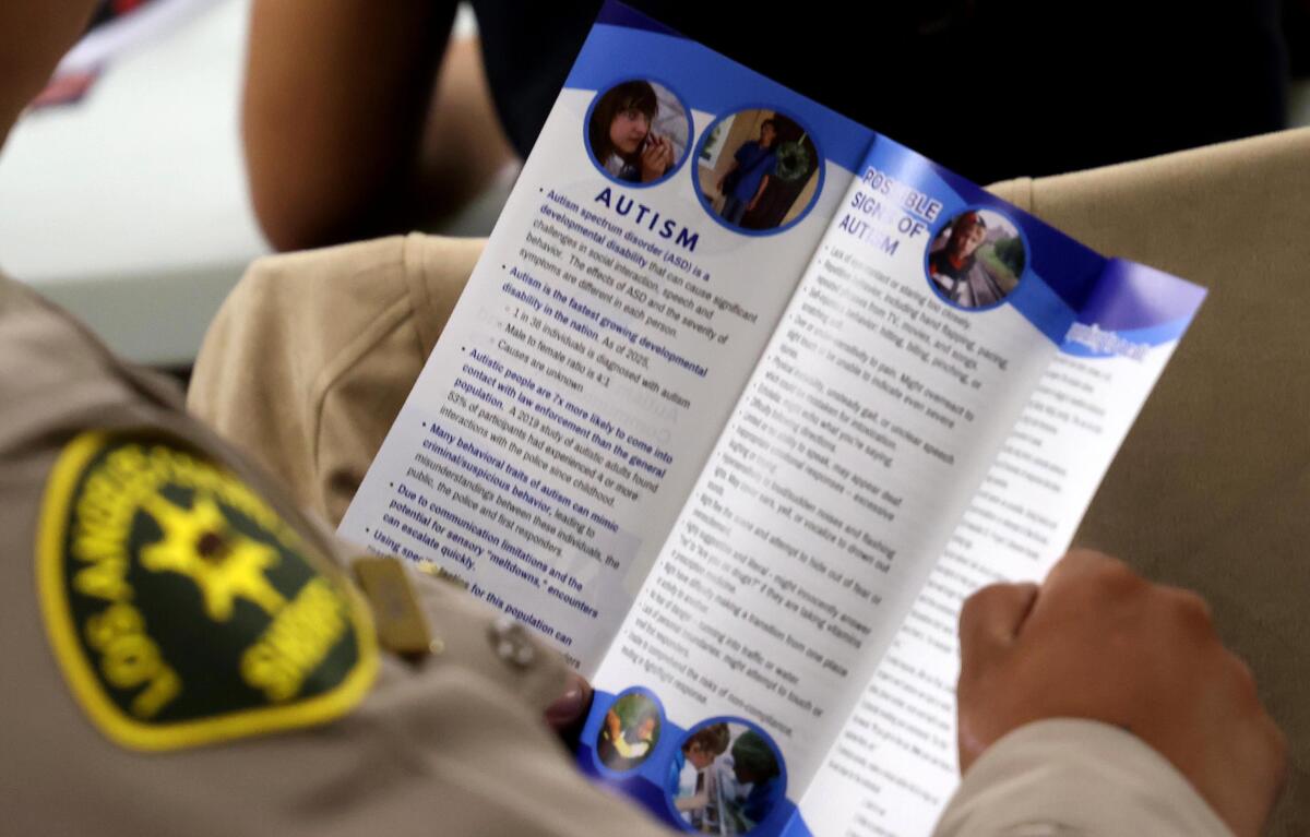 A sheriff's deputy reads a pamphlet on autism during the training program.