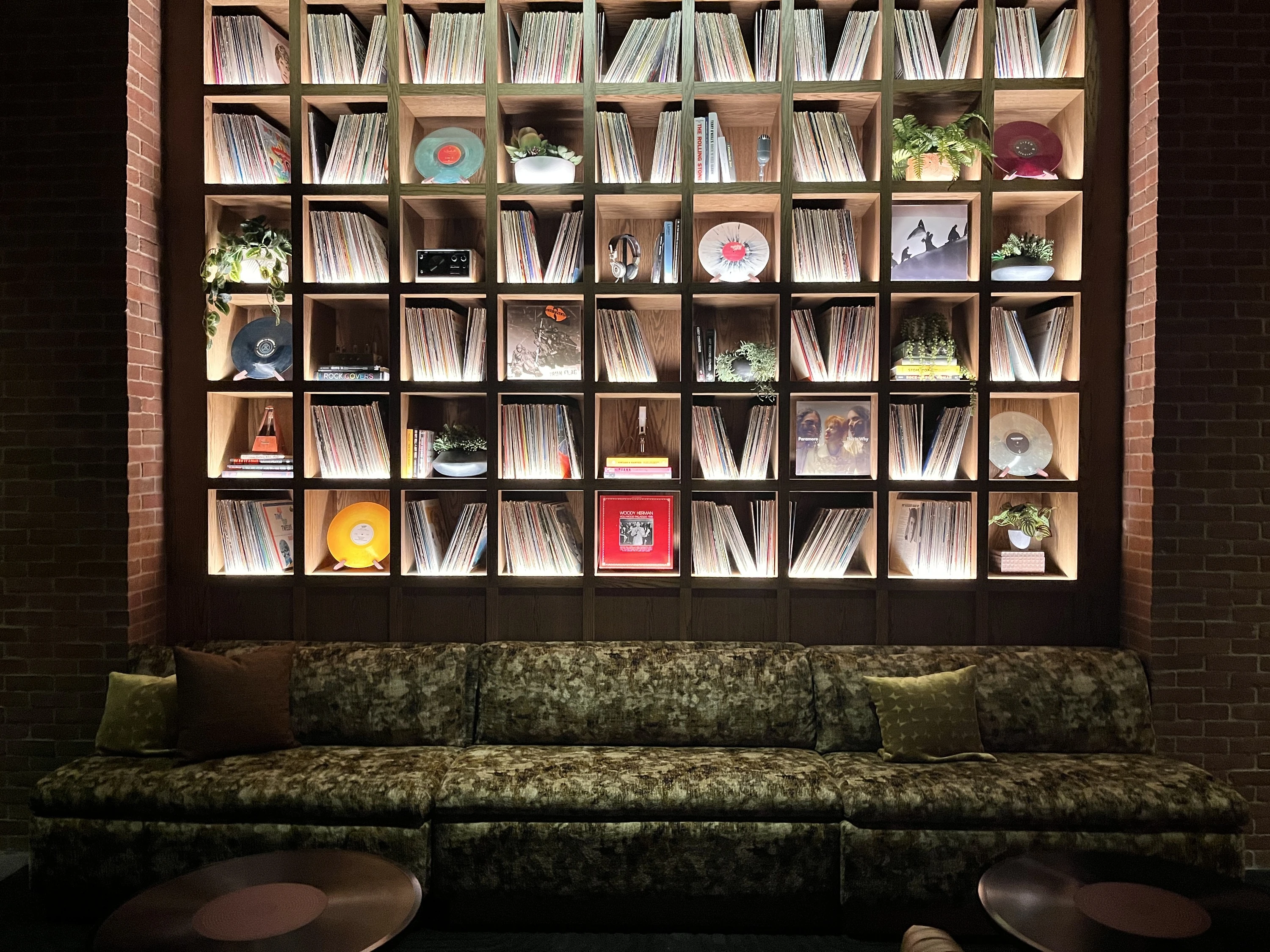 A couch under shelves of vinyl records.