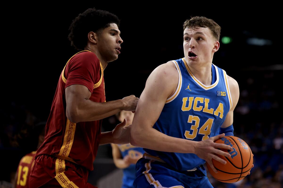 UCLA forward Tyler Bilodeau is defended by USC forward Jacob Cofie in the first half.