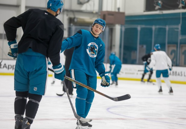 San Jose Sharks' Macklin Celebrini (71) and San Jose Sharks' Vincent Desharnais (5) talk during the first practice after the Olympics at Tech CU Arena in San Jose, Calif., on Wednesday, Feb. 25, 2026. (Shae Hammond/Bay Area News Group)