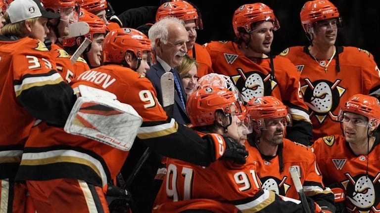 Anaheim Ducks head coach Joel Quenneville, center, poses with players...