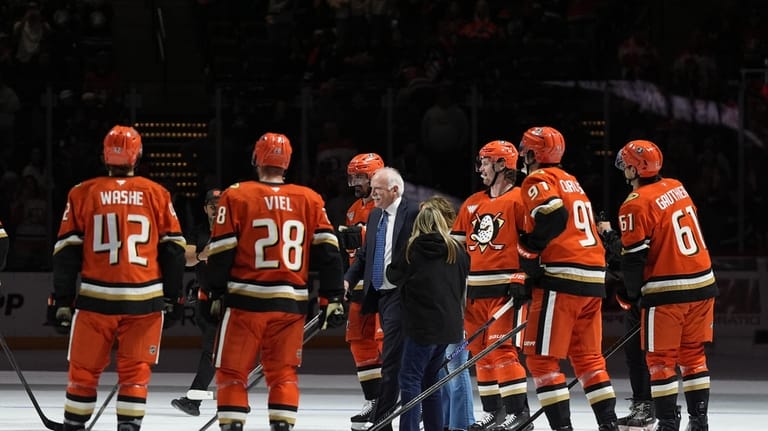 Anaheim Ducks head coach Joel Quenneville, center, celebrates with players...