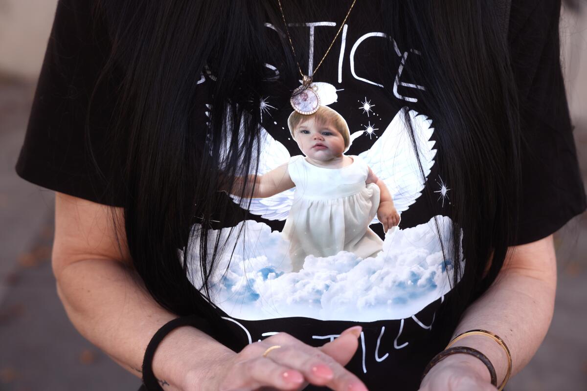 A person in a black T-shirt with the image of a young girl in a white dress, with wings, and clouds