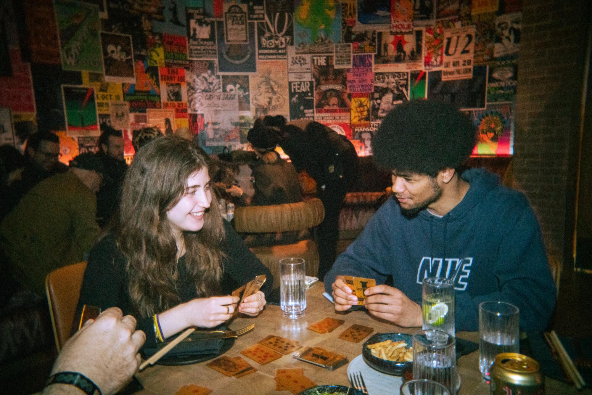 Two people play cards at Vinyl Room.