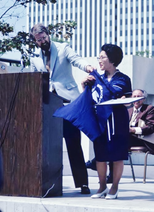 Coastal Commissioner Mel Nutter hands Long Beach Mayor Eunice Sato the keys to the city and a t-shirt that reads "Coastal Bureaucratic Thugs" following the city earning its Local Coastal Program certification. (Photo courtesy of Nutter)