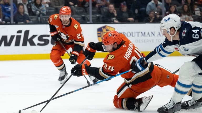Anaheim Ducks center Jansen Harkins, center, and Winnipeg Jets defenseman...