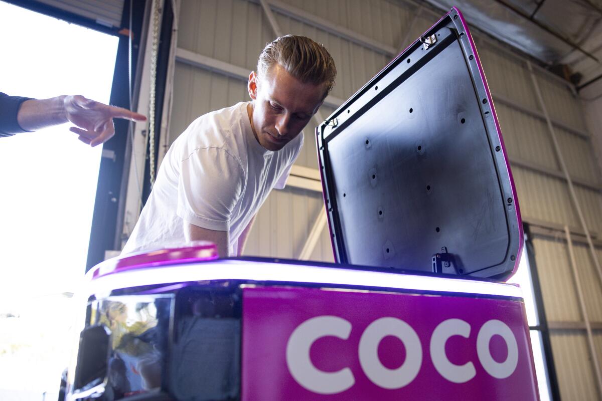 Zach Rash opens the top of the new Coco 2 (Next-Gen) at the Coco Robotics headquarters in Venice.