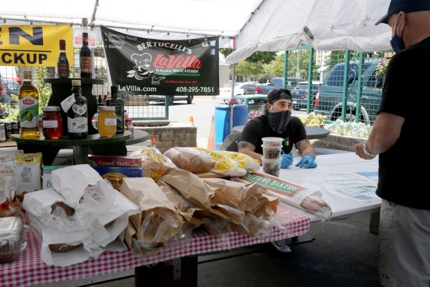 During COVID, La Villa operated a makeshift outdoor deli for customer safety. Here, co-owner Chris Bertucelli takes a food order from a customer. (Ray Chavez/Bay Area News Group)