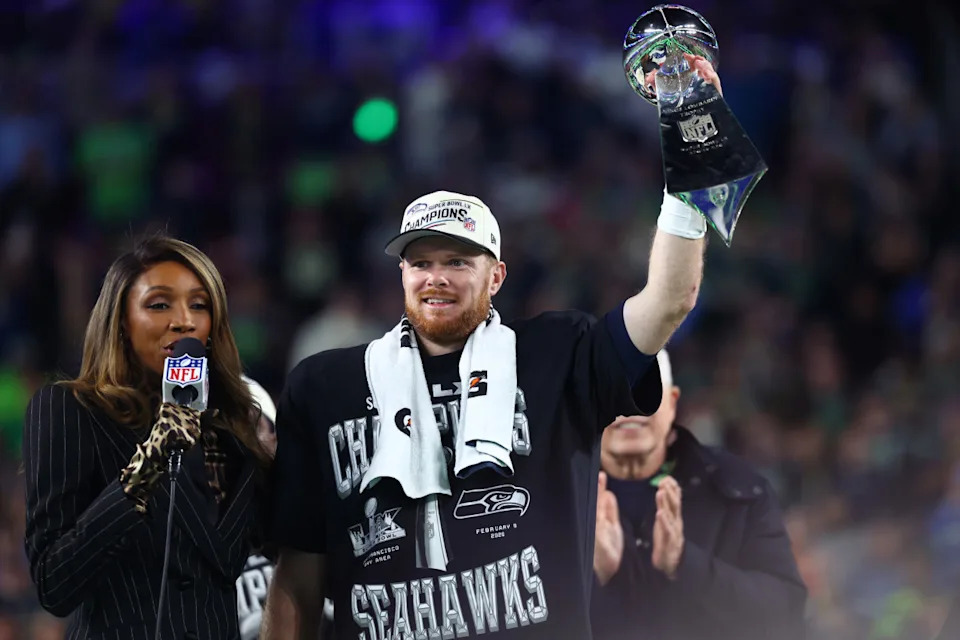 Seattle Seahawks quarterback Sam Darnold (14) celebrates with the Vince Lombardi trophy on the podium after defeating the New England Patriots in Super Bowl LX at Levi's Stadium.Mark J. Rebilas-Imagn Images