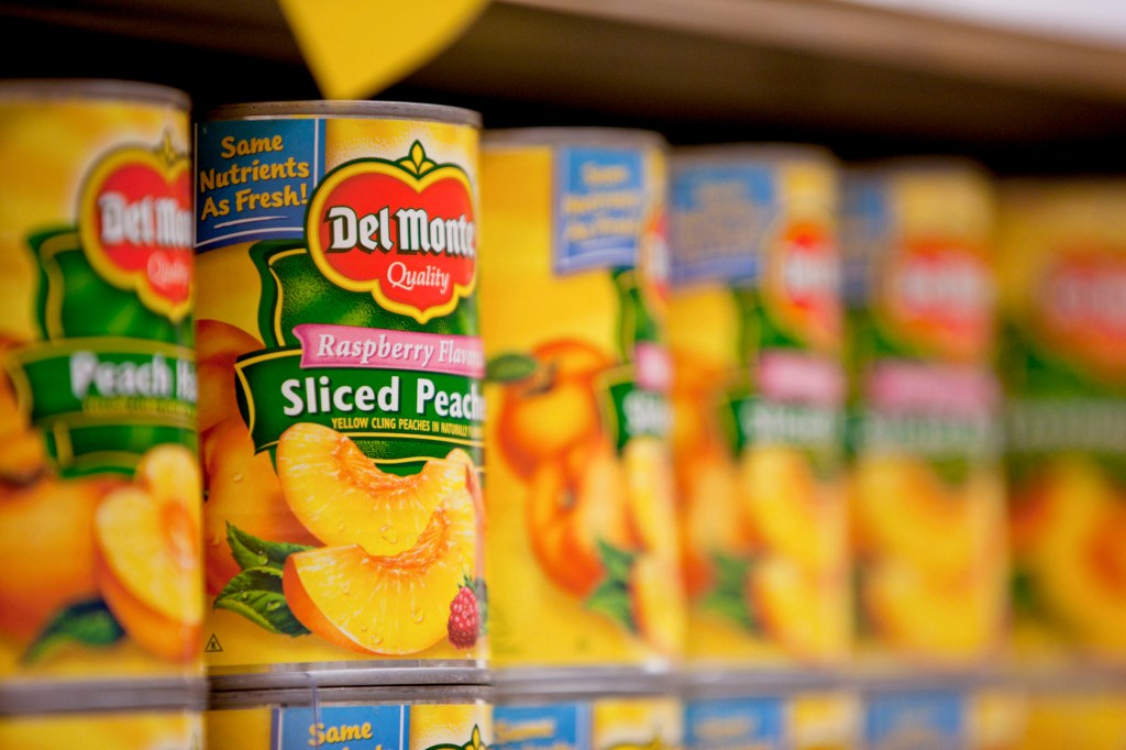 Cans of Del Monte Foods Co. canned peaches on a shelf.