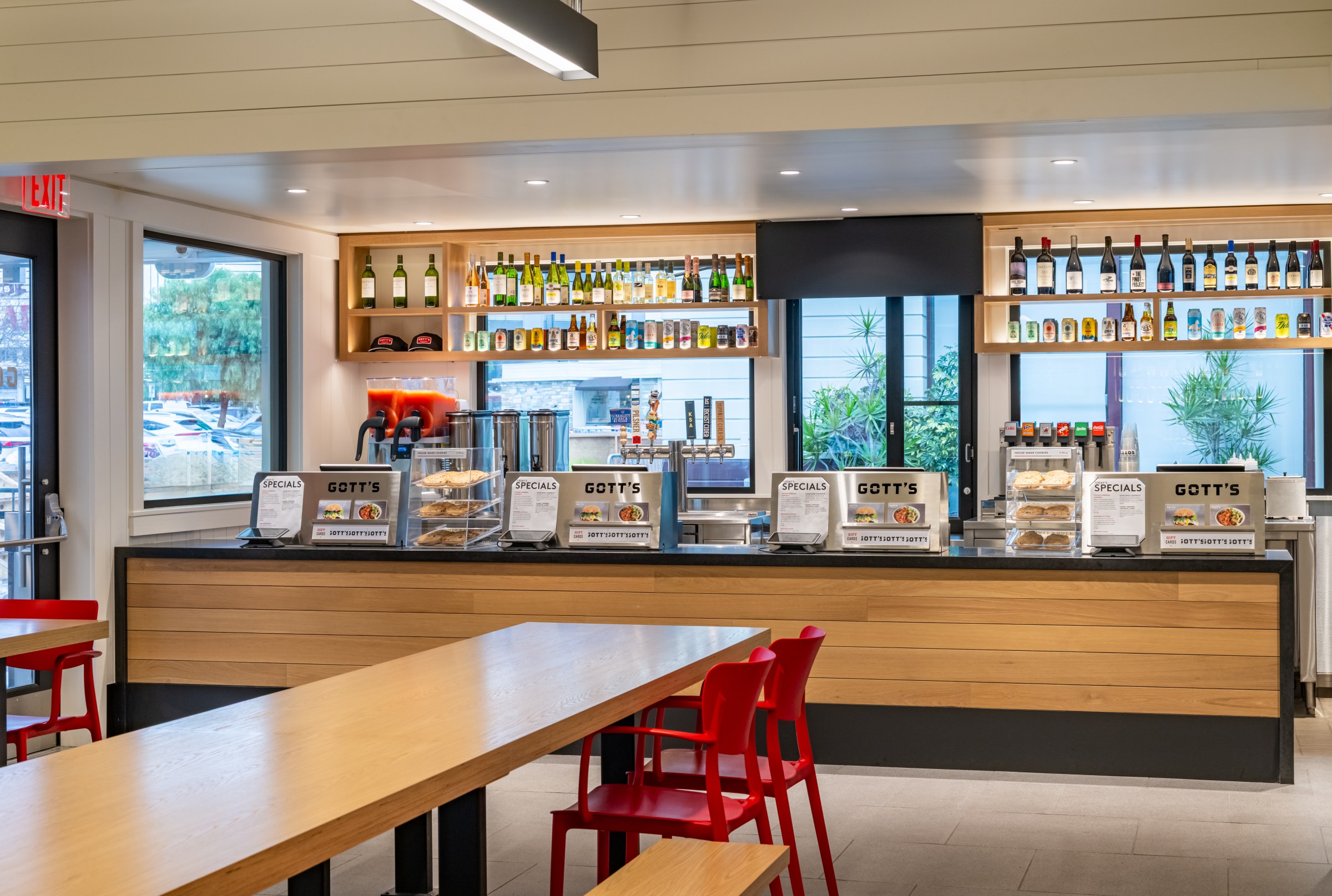 Interior service area at Gott’s with a wood counter and wine bottles.