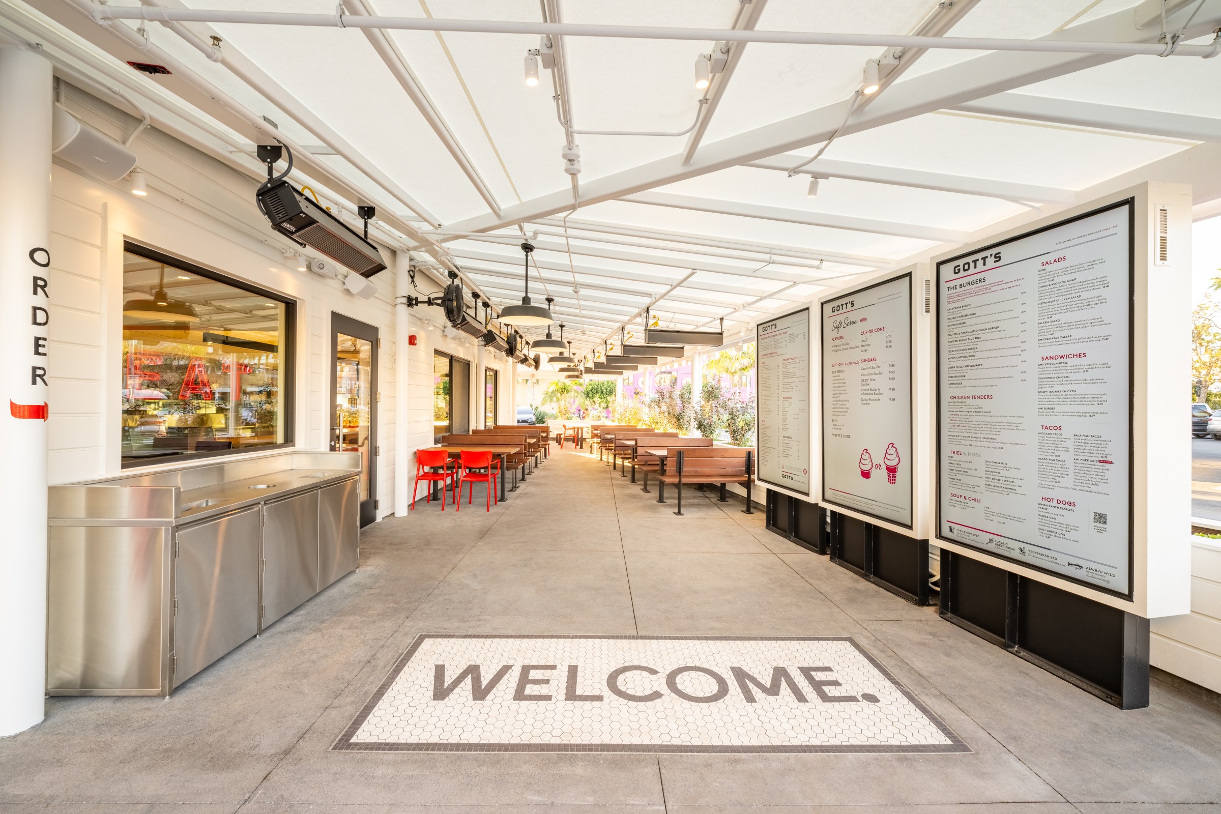Exterior patio at Gott’s with a tiled “welcome” sign on the floor.