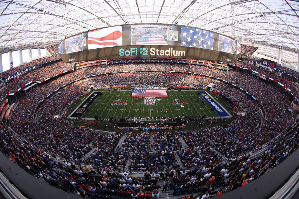 General view of SoFi Stadium during Super Bowl LVI with an American flag covering the field during the national anthem.
