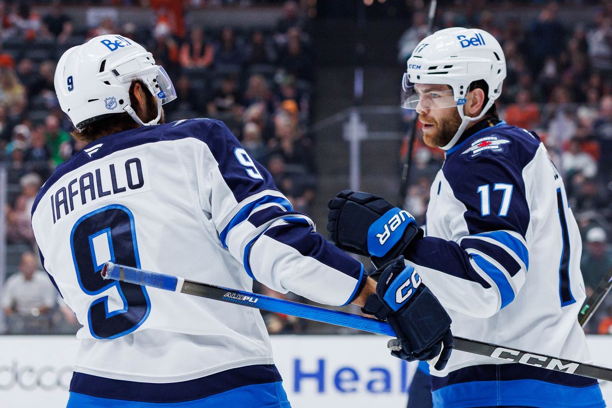 Winnipeg Jets left wing Alex Iafallo (9) celebrates after scoring a goal with center Adam Lowry (17) during an NHL match against the Anaheim Ducks on February 27, 2026 in Anaheim, California.
