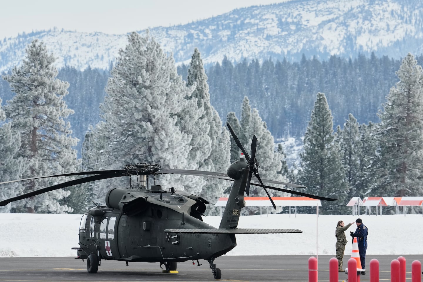 A member of the US Army and a member of the California Highway Patrol spoke on the runway at the Truckee Tahoe Airport amid recovery efforts for a group of missing skiers in Truckee, Calif., on Saturday.