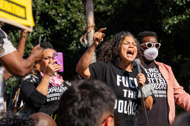 Melina Abdullah stands in the center of the crowd, passionately delivering her speech in a black t-shirt printed with "Fuck the police."