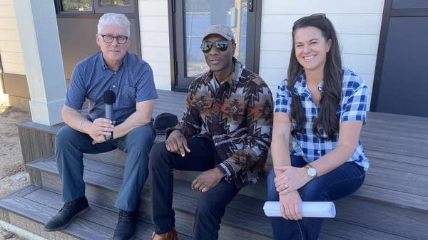 David Brancaccio, Aloe Blacc, and Jenn Largesse pose on the steps of a house