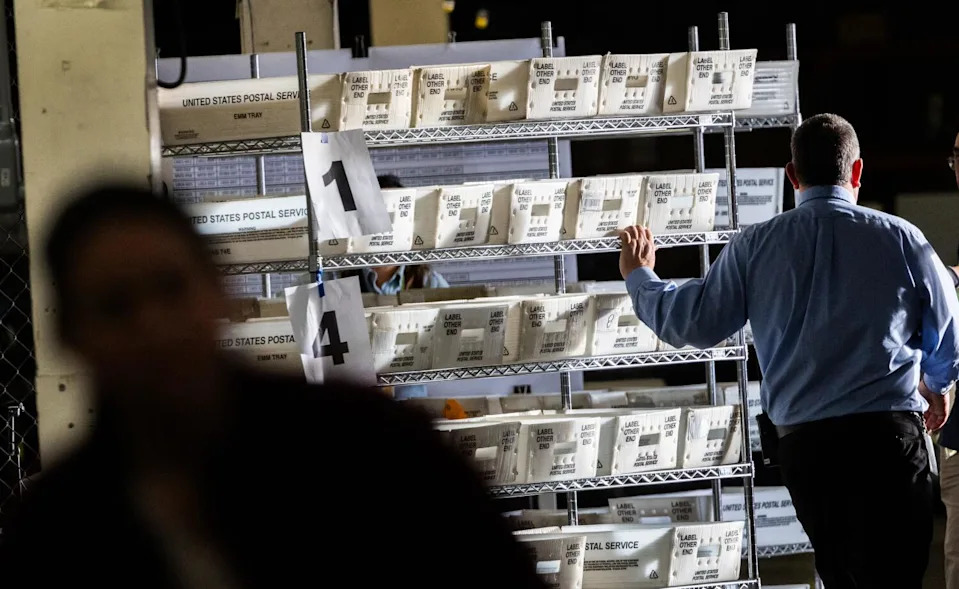 An election worker moves ballots to be sorted.