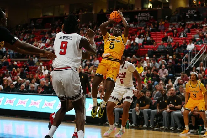 Nov 30, 2025; Lubbock, Texas, USA; Wyoming Cowboys guard Leland Walker (5) shoots a fadeaway shot against Texas Tech Red Raiders forward Luke Bamgboye (9) in the second half at United Supermarkets Arena.