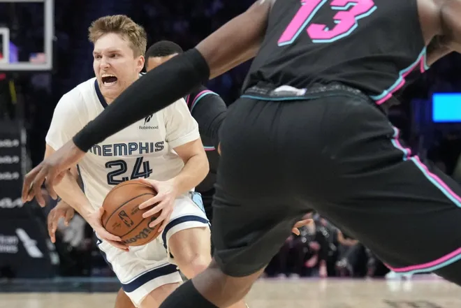 Feb 21, 2026; Miami, Florida, USA; Memphis Grizzlies guard Cam Spencer (24) drives to the basket as Miami Heat center Bam Adebayo (13) defends during the first half at Kaseya Center.