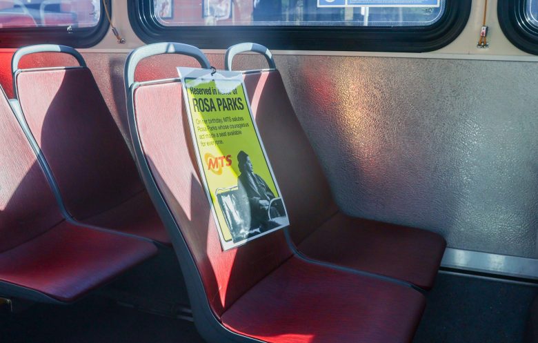 A sign showing a seat has been "reserved" for Rosa Parks on MTS's Transit Equity Day. (Image by Adrian Childress/Times of San Diego)