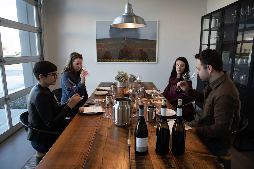 Erin Brooks, second from left, hosts a tasting in 2019 at Grand Cru Custom Crush for customers, from left, Gaby Antunes, Brittany Ballard and Michael Sprague. (Paul Kuroda/For the S.F. Chronicle)