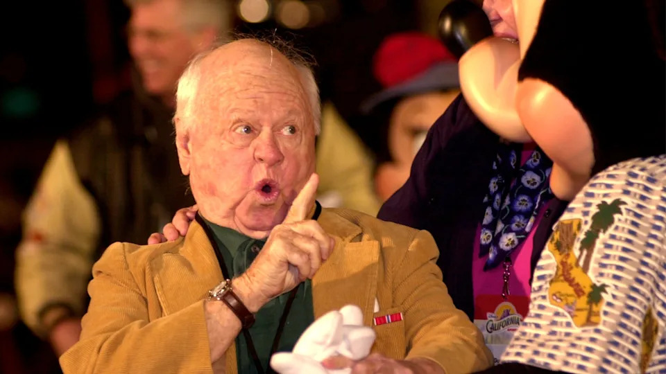 Actor Mickey Rooney jokes with a Mickey Mouse mascot at a V.I.P. grand opening partyGetty