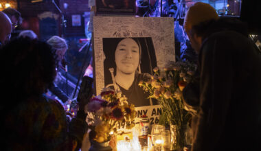 A photo of a man in a beanie is surrounded by candles