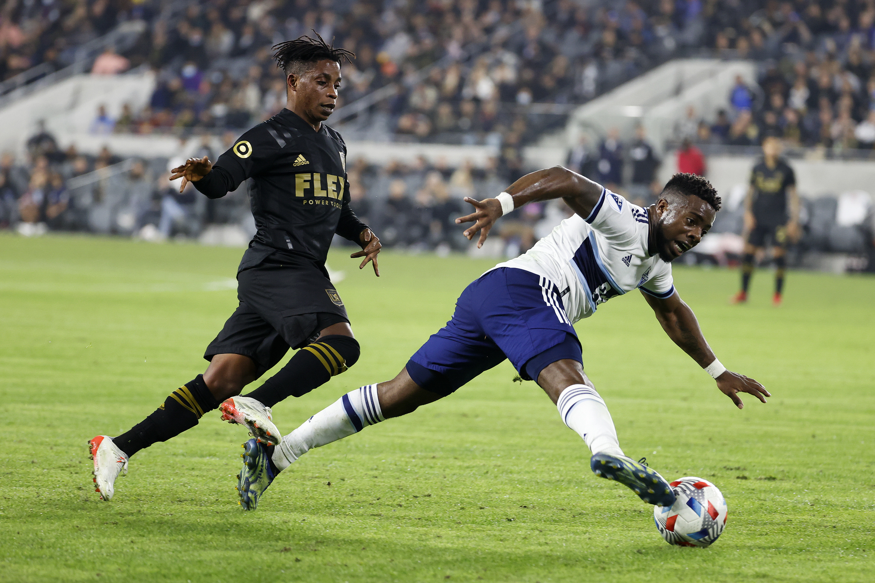 Vancouver Whitecaps forward Cristian Dajome, right, drives the ball away...