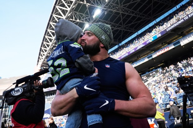 Seattle Seahawks linebacker Patrick O'Connell kiss his son Patrick Jr. before the NFC Championship NFL football game against the Rams, Sunday, Jan. 25, 2026, in Seattle. (AP Photo/Godofredo A. Vásquez)