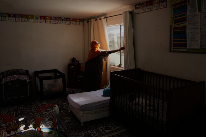 Samsam Khalif closes curtains as she prepares for nap time at her home-based child care center Friday, Jan. 30, 2026, in San Diego. (AP Photo/Gregory Bull)