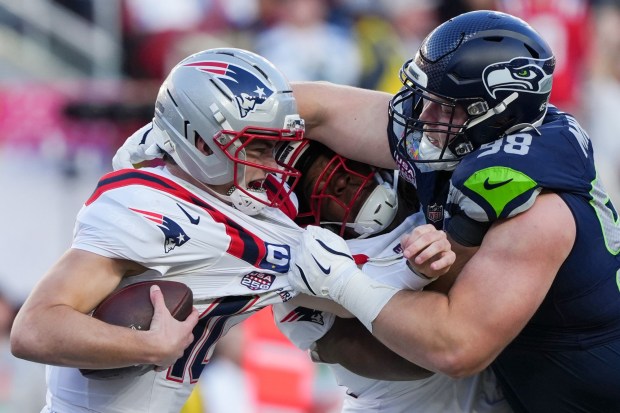 Seattle Seahawks defensive end Rylie Mills, right, sacks New England Patriots quarterback Drake Maye, left, during the first half of the NFL Super Bowl 60 football game, Sunday, Feb. 8, 2026, in Santa Clara, Calif. (AP Photo/Matt Slocum)