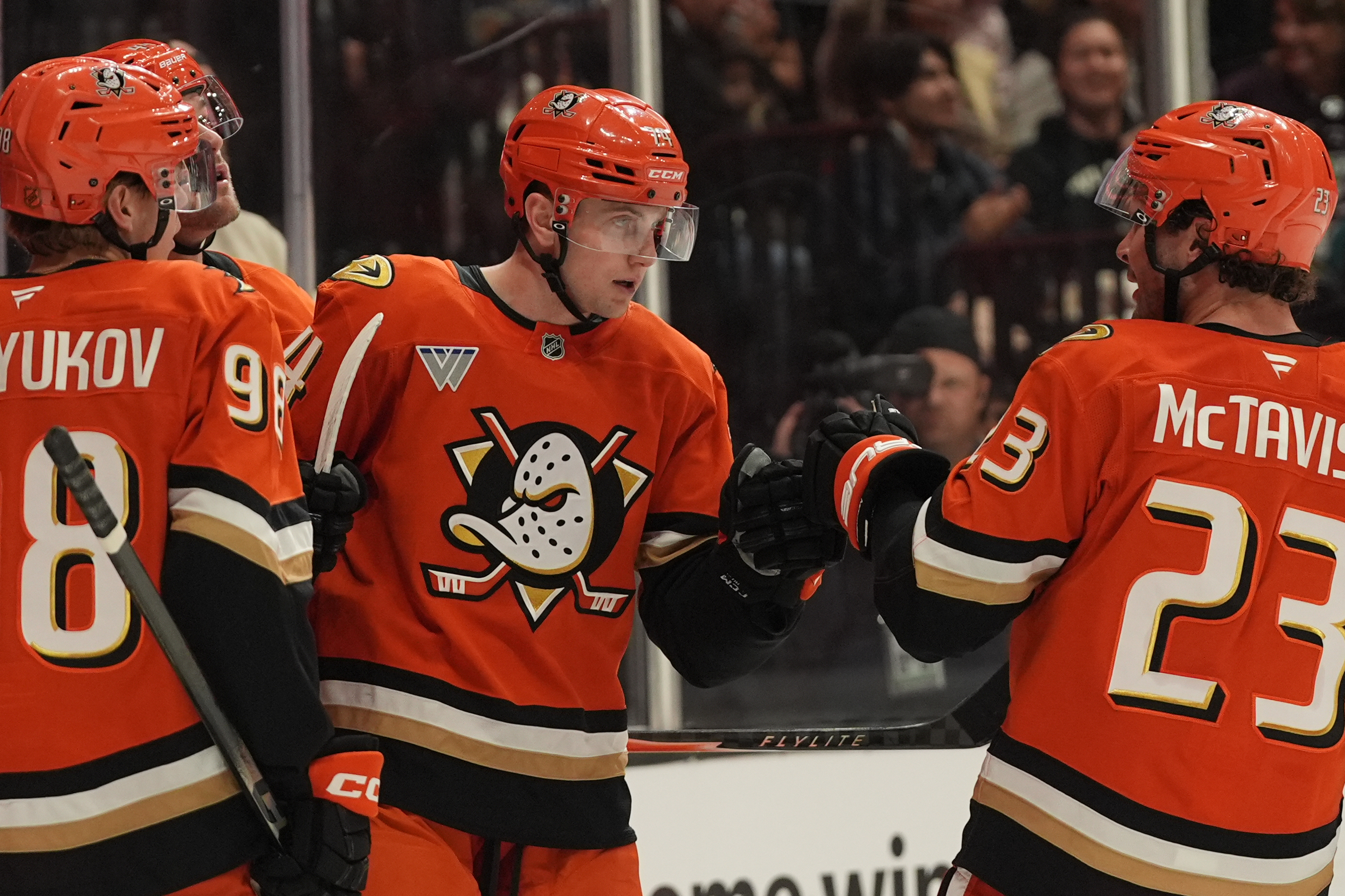 Ducks defenseman Ian Moore, center, celebrates his goal with teammates...