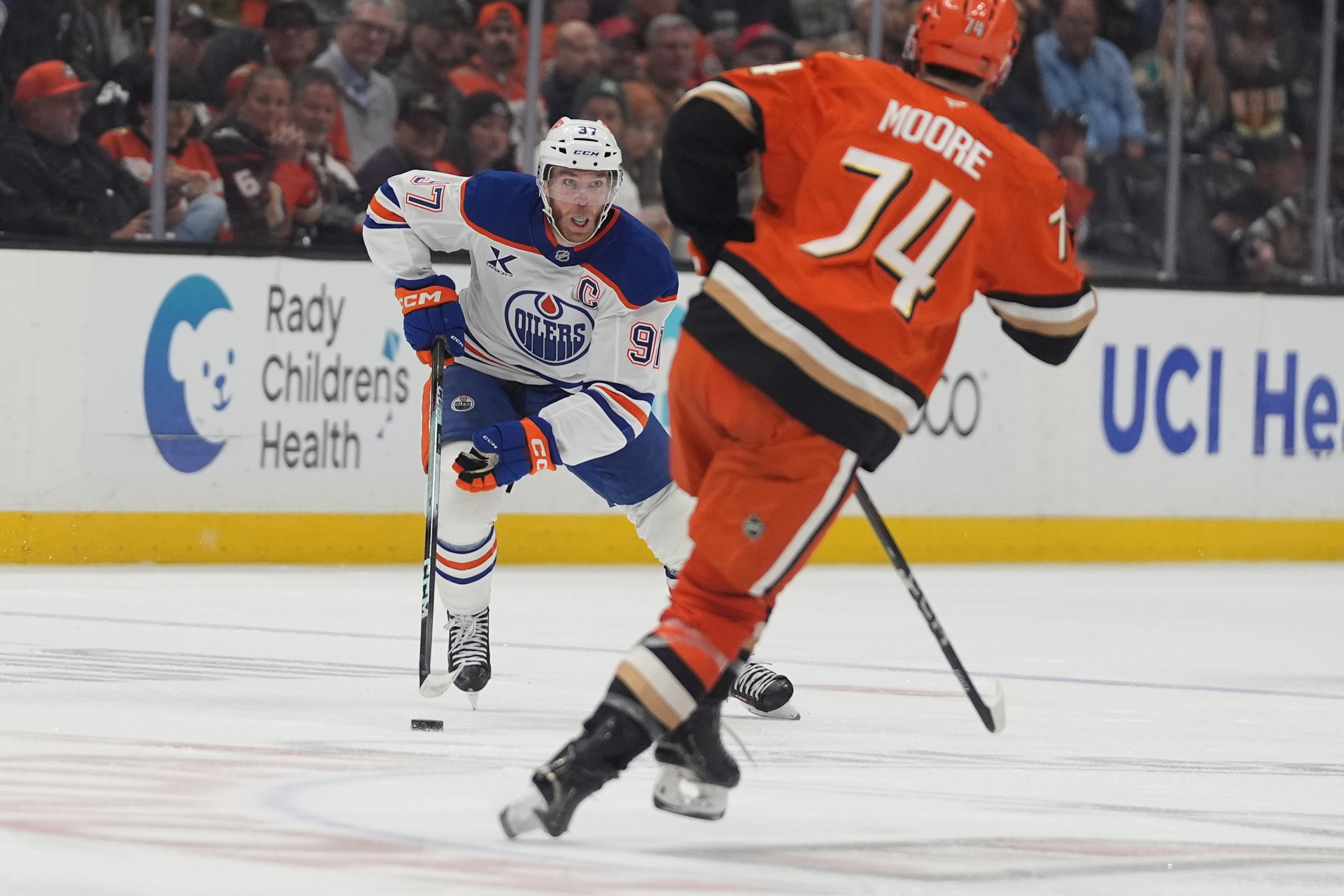 Edmonton Oilers center Connor McDavid, left, looks to pass the...