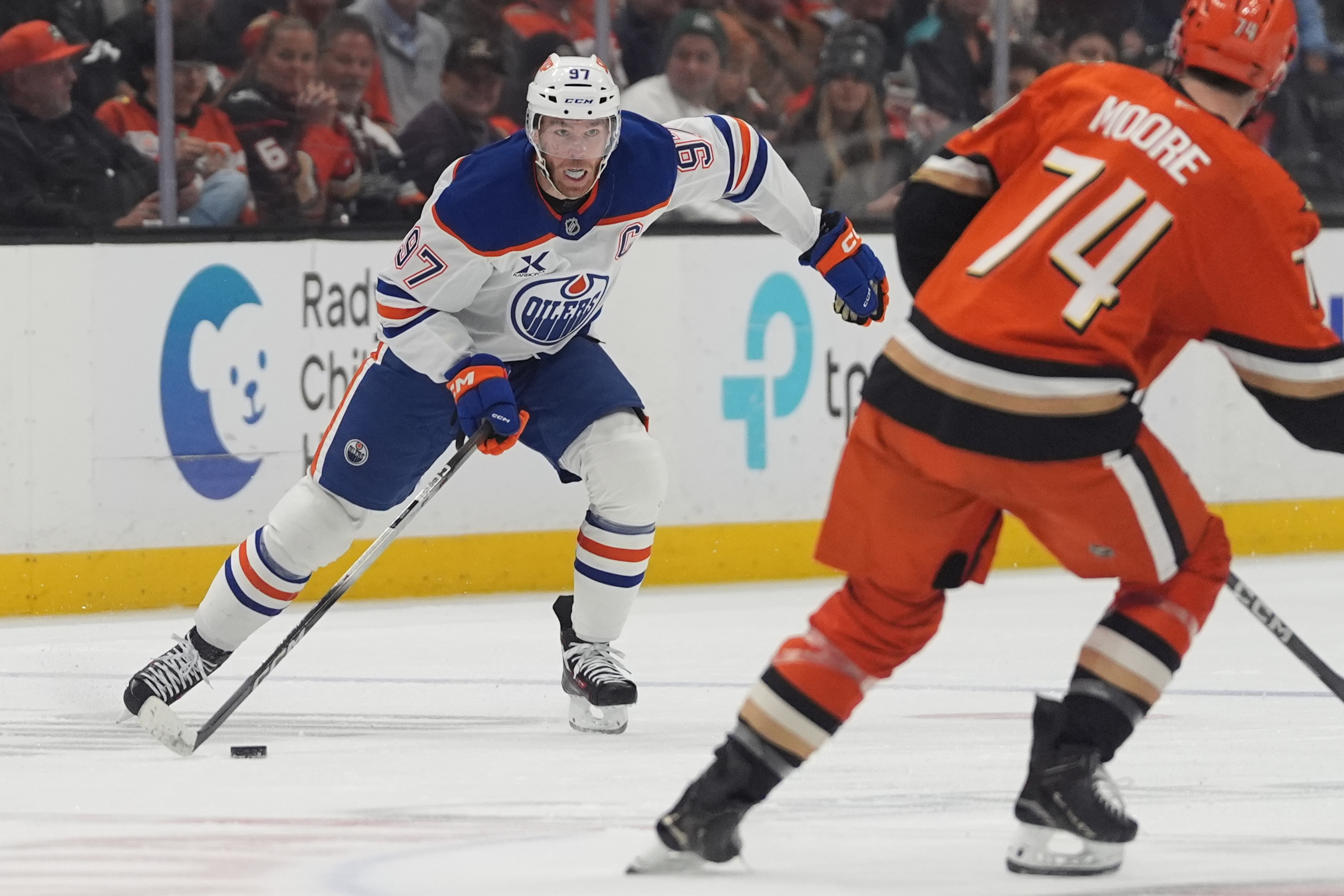 Edmonton Oilers center Connor McDavid, left, looks to pass the...
