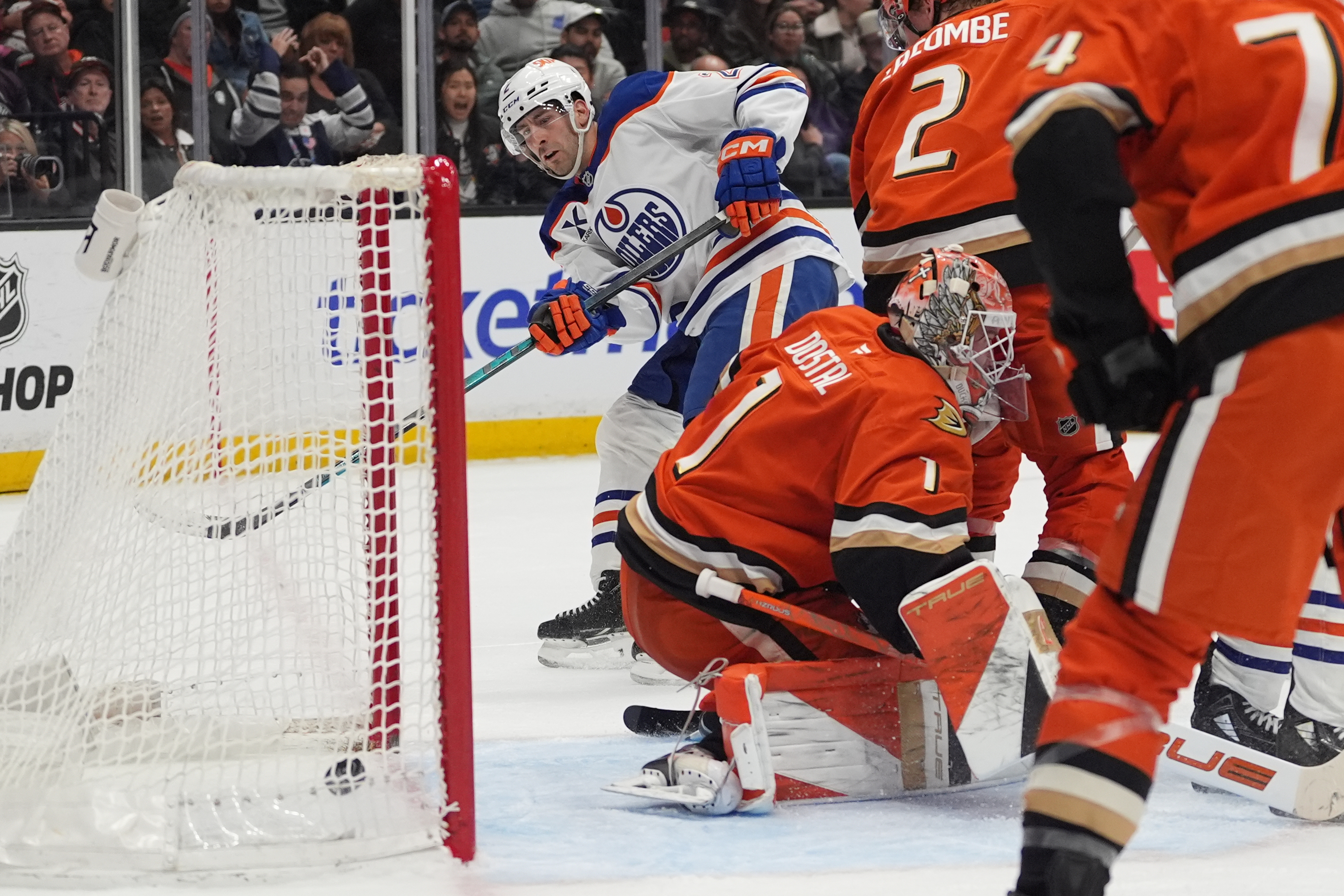 Edmonton Oilers defenseman Evan Bouchard, left, watches his shot get...
