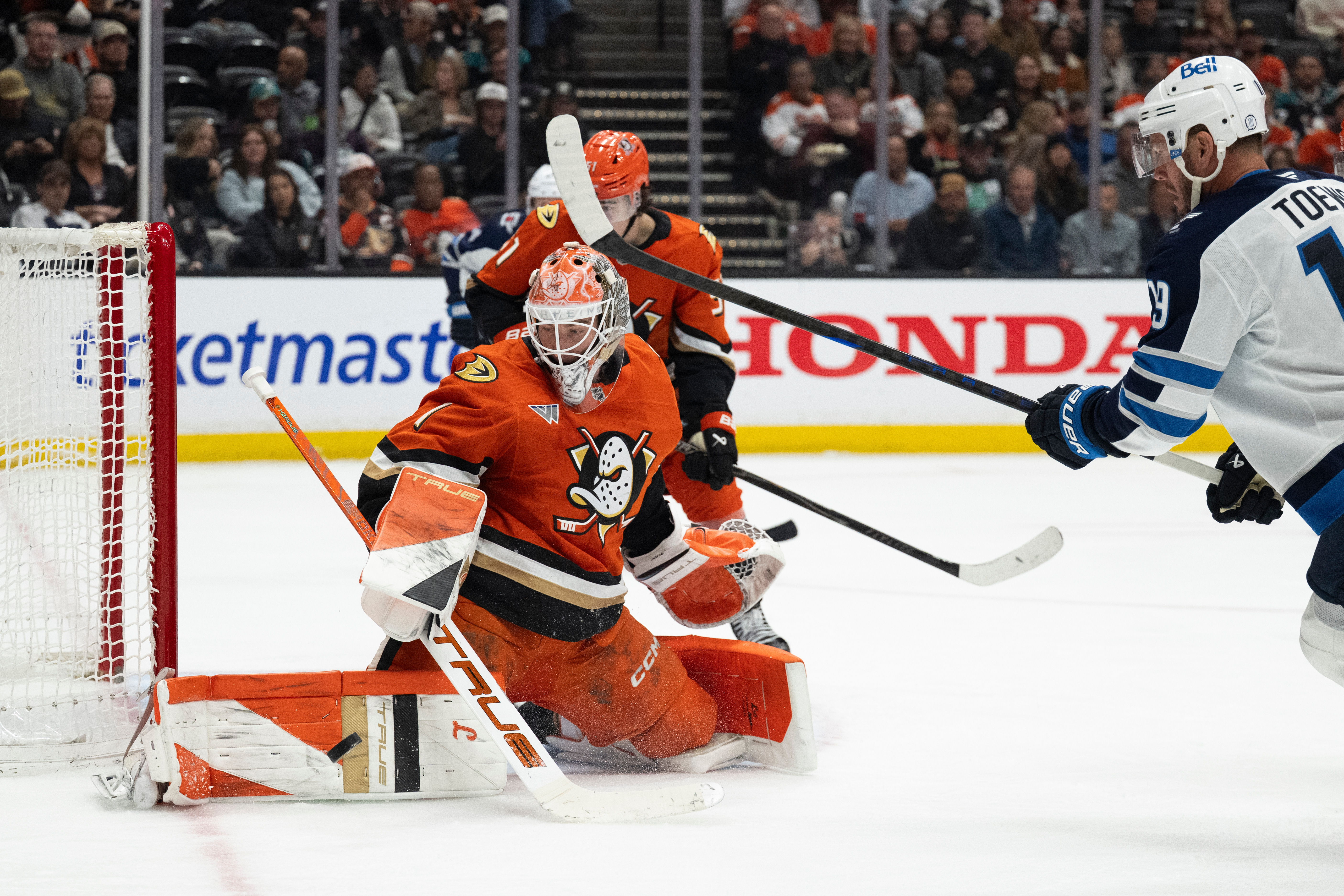 Ducks goaltender Lukas Dostal, front left, blocks a shot in...