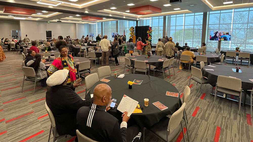 large conference room with tables and attendees socializing