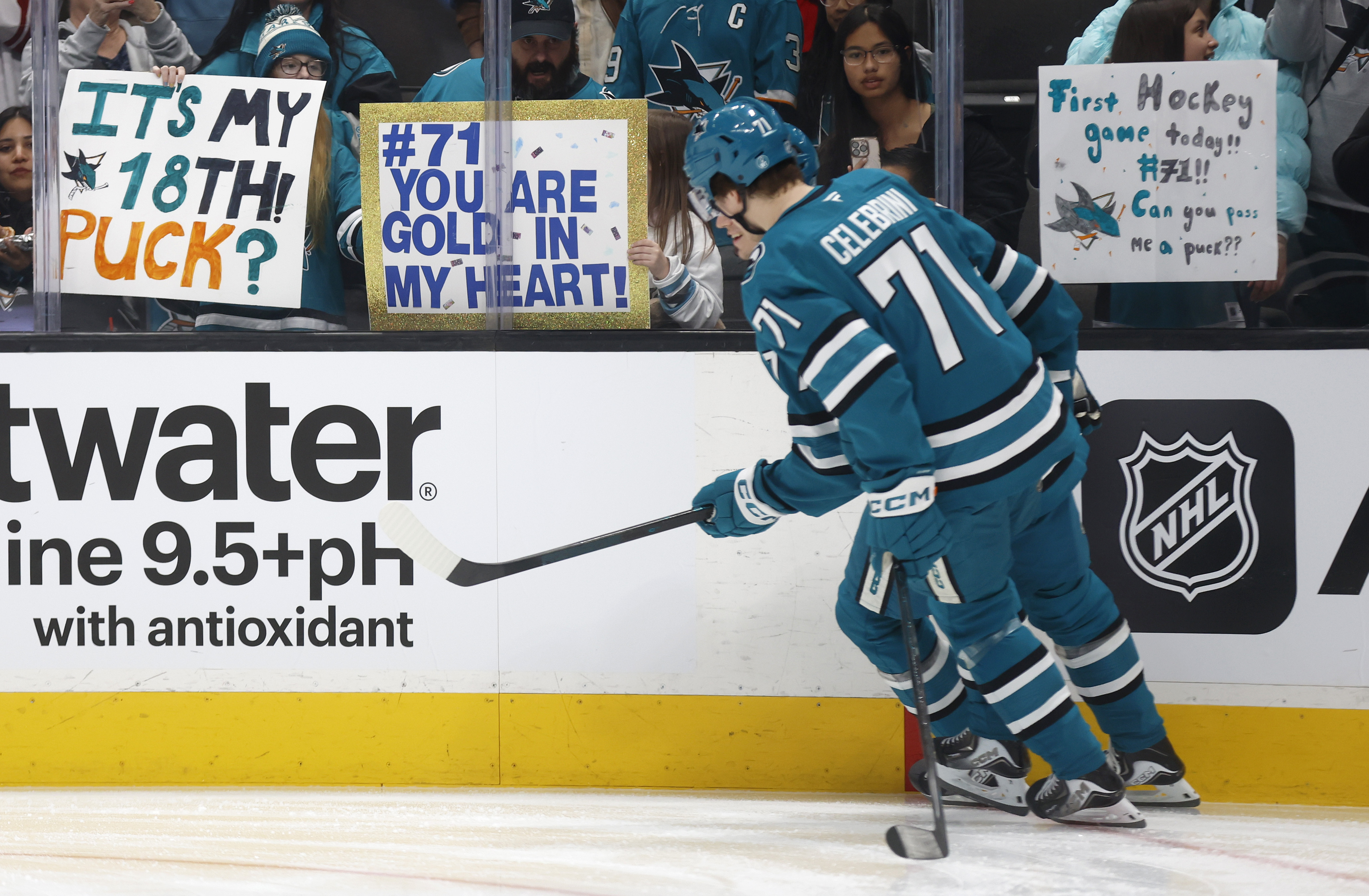 San Jose Sharks’ Macklin Celebrini (71) skates past a sign...