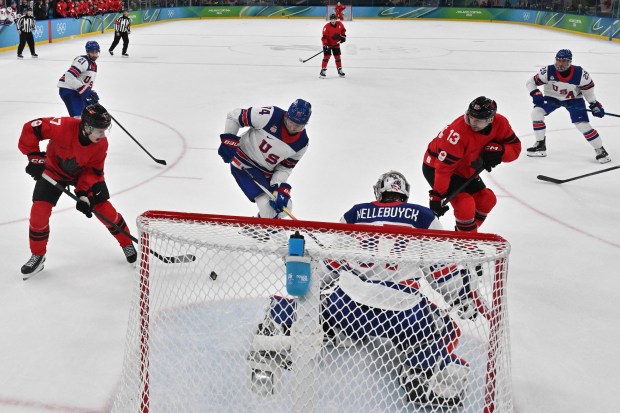 MILAN, ITALY - FEBRUARY 22: USA's #74 Jaccob Slavin (2L) and Canada's #17 Macklin Celebrini vie for the puck during the men's gold medal ice hockey match between Canada and USA at the Milano Santagiulia Ice Hockey Arena during the Milano Cortina 2026 Winter Olympic Games on February 22, 2026 in Milan, Italy. (Photo by Julien de Rosa - Pool/Getty Images)