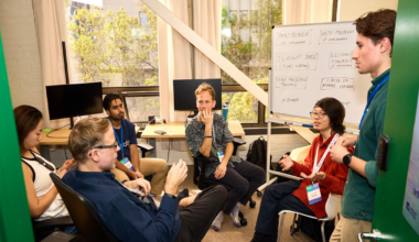 A digital wireframe human face on the right merges with an abstract circuit board design on the left, symbolizing the connection between technology and humanity.
