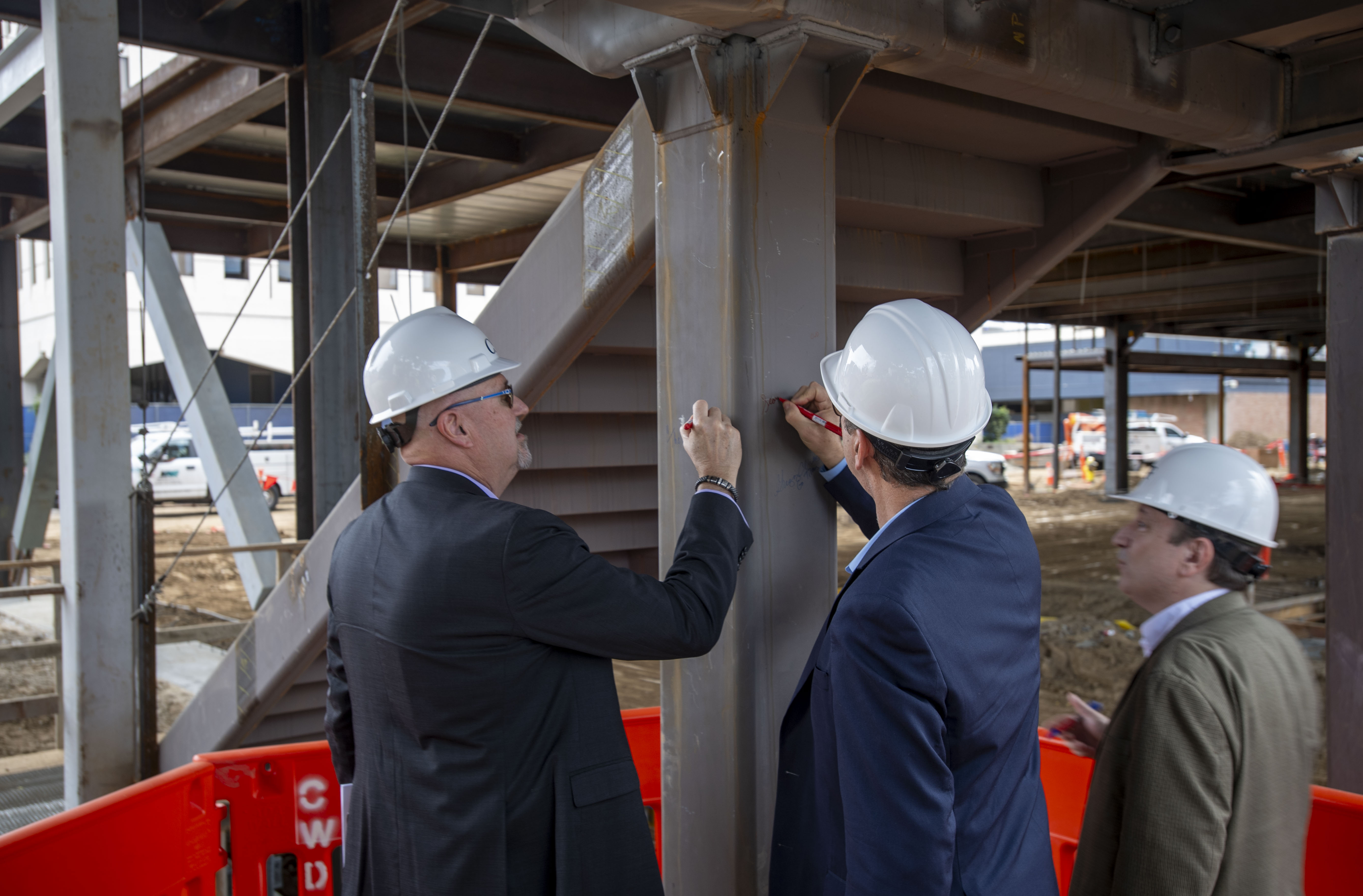 Guests sign the beam during the CSUF College of Engineering...