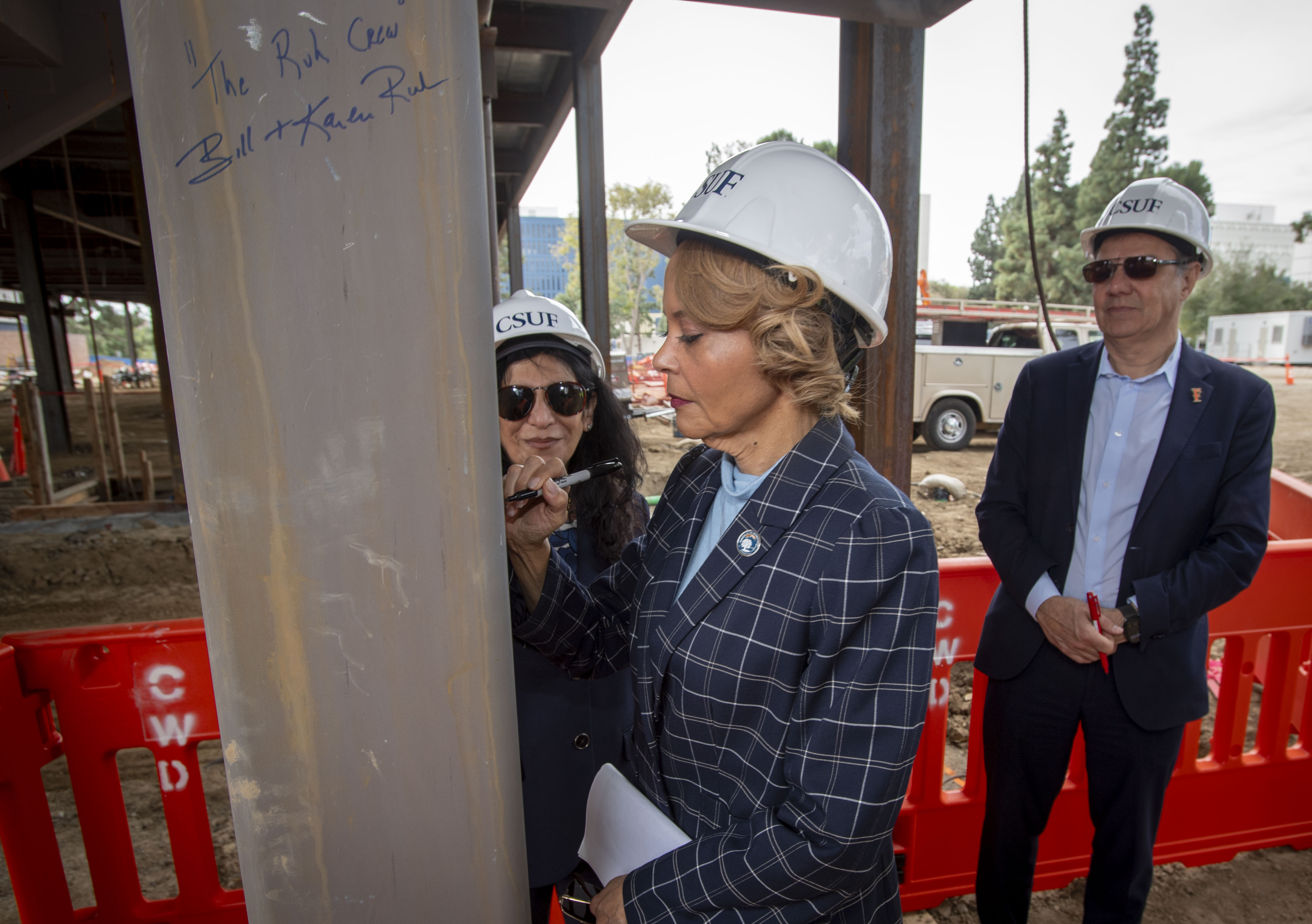 Guests sign the beam during the CSUF College of Engineering...