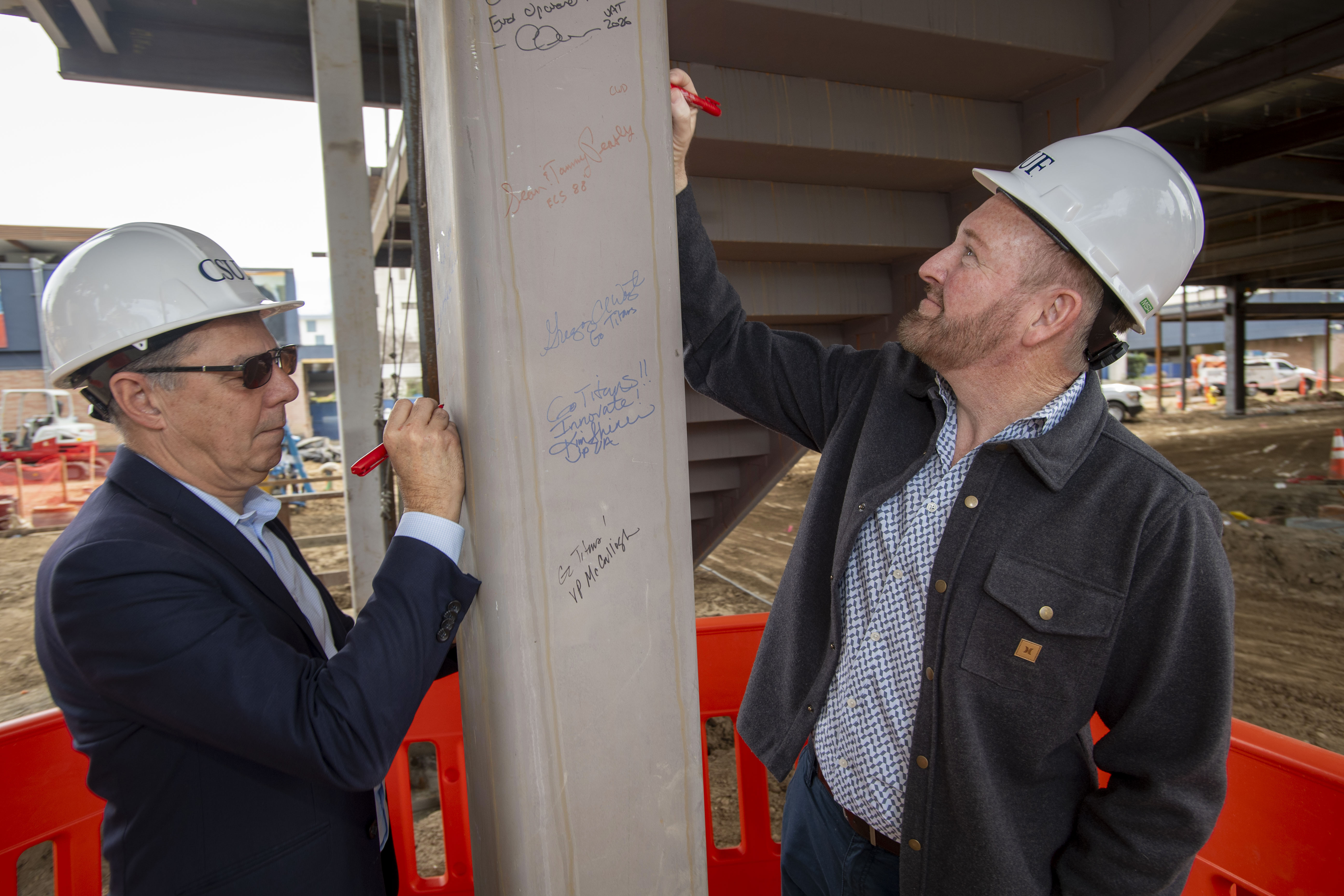 Guests sign the beam during the CSUF College of Engineering...
